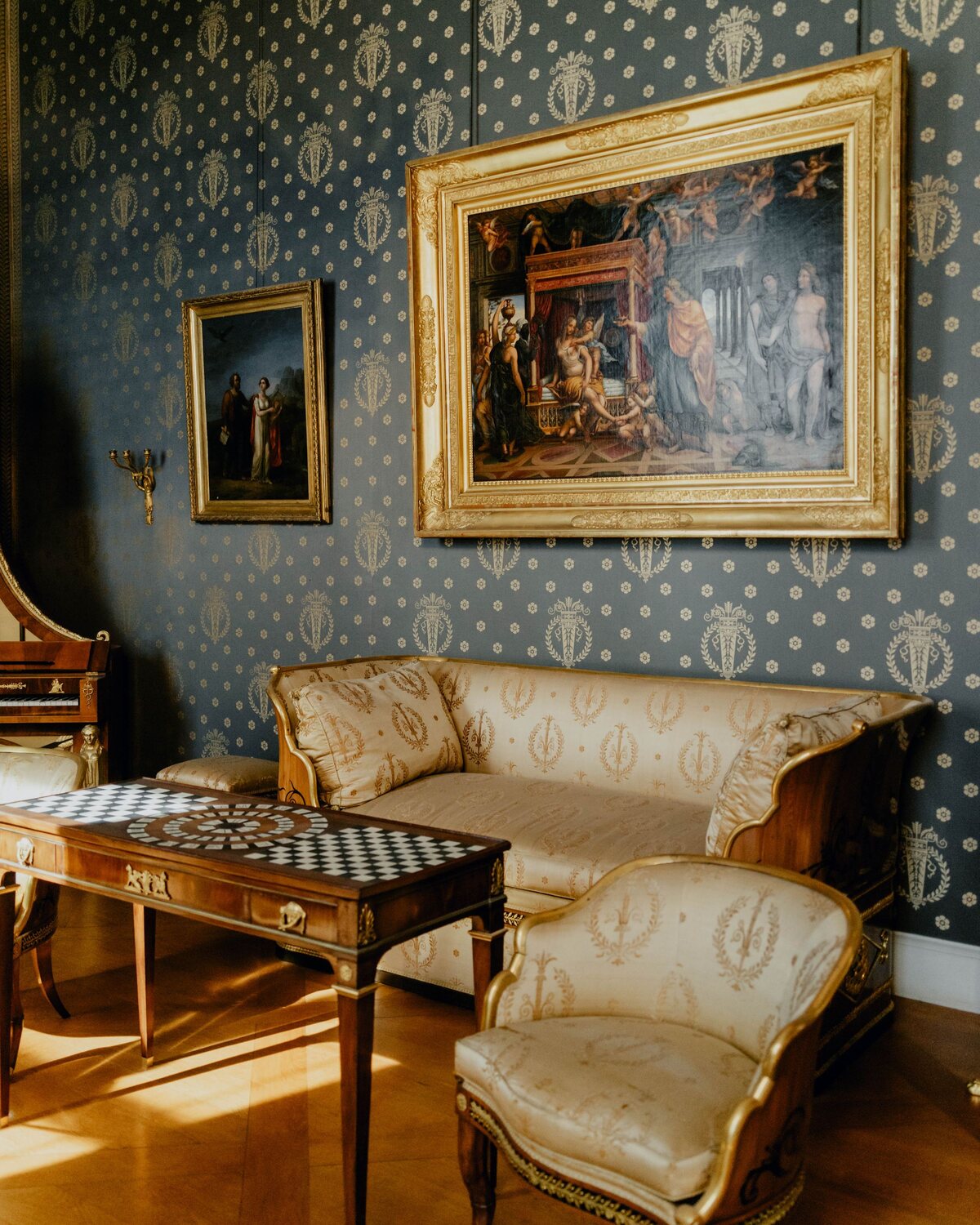 Elegant living room with blue-and-gold patterned wallpaper and refined furniture