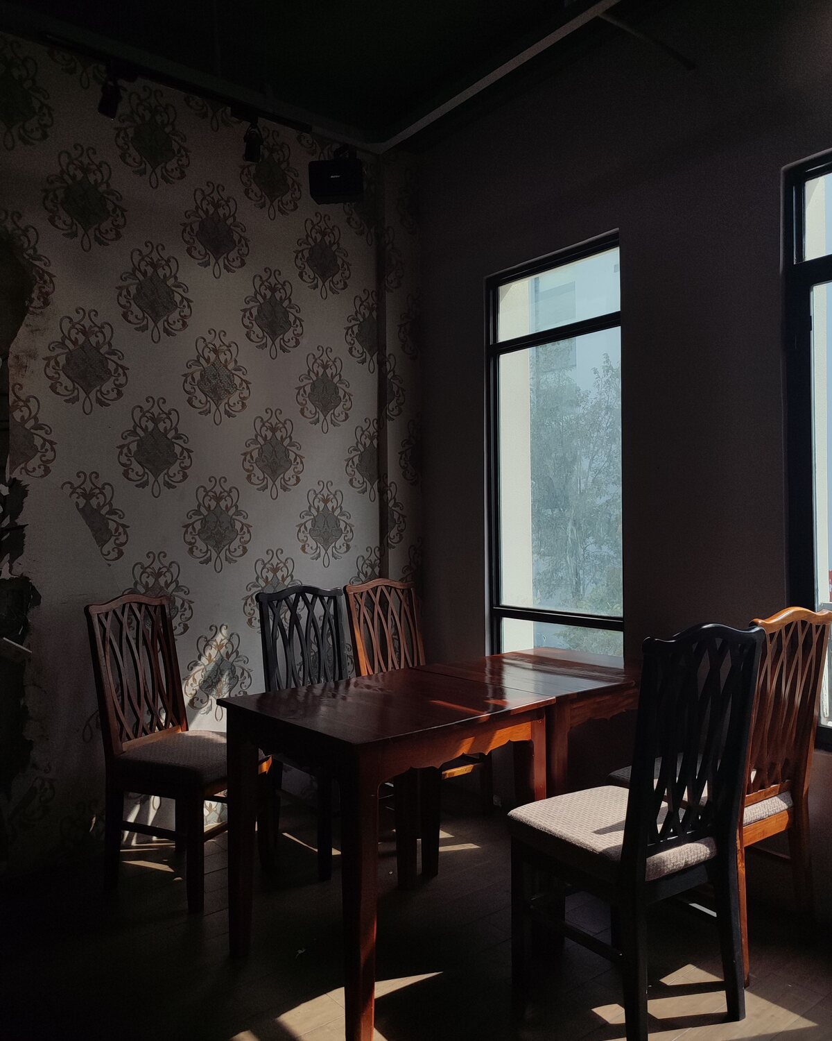 Dining room with dark damask wallpaper and a classic wooden table